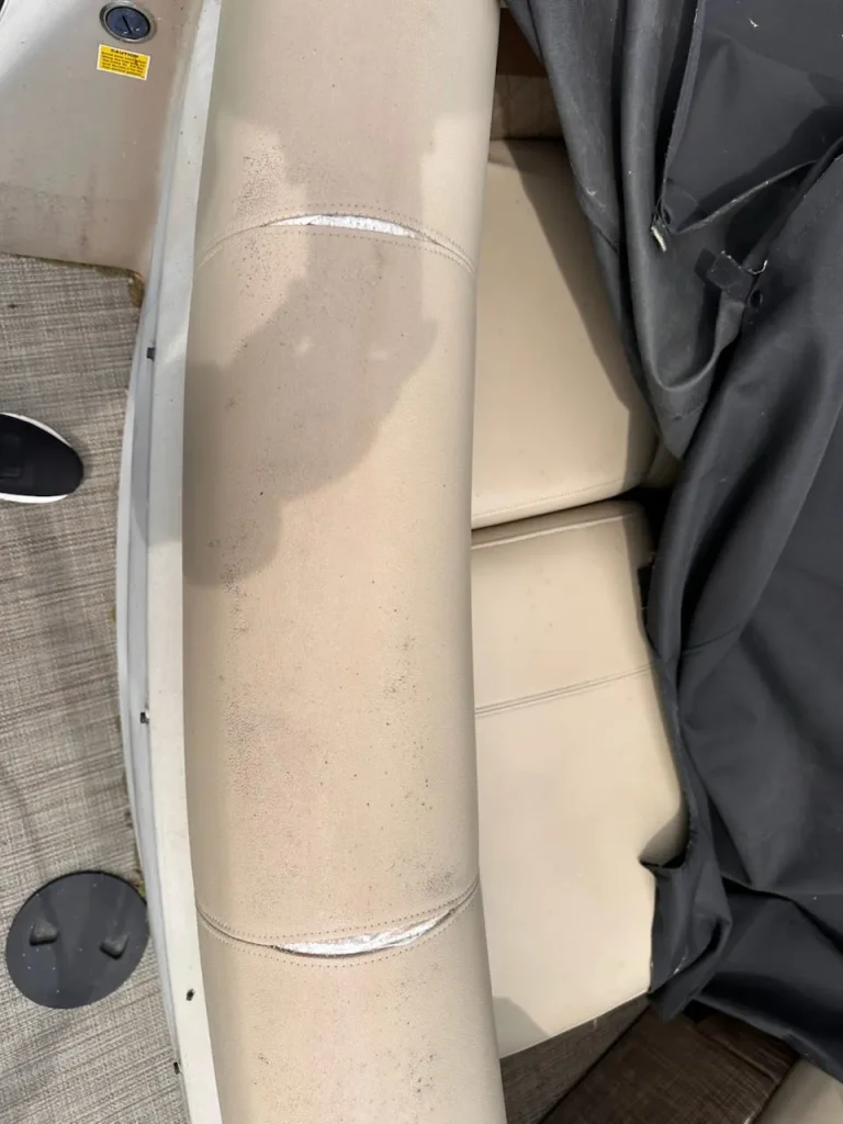 Separated seams on a beige boat seat before marine vinyl repair in Cornelius, NC