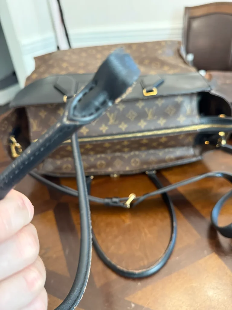 Damaged black leather handles on a designer handbag before repair in Ballantyne, Charlotte, NC