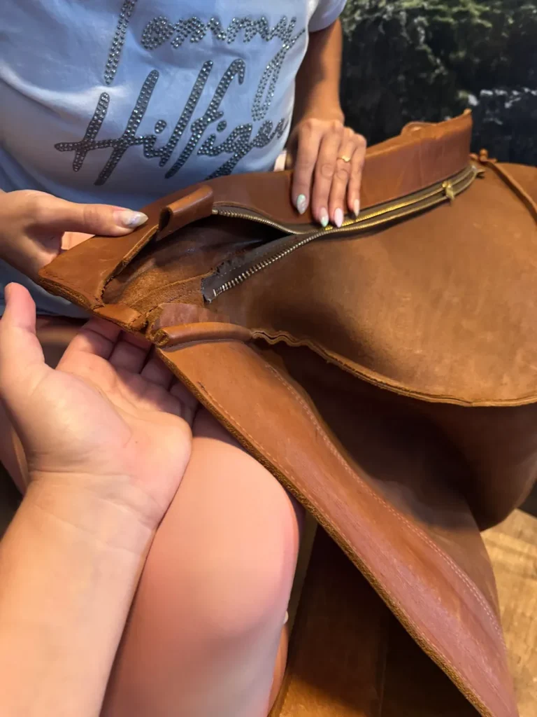 Technician repairing a separated seam on a brown leather showroom chair in Myers Park, Charlotte, NC