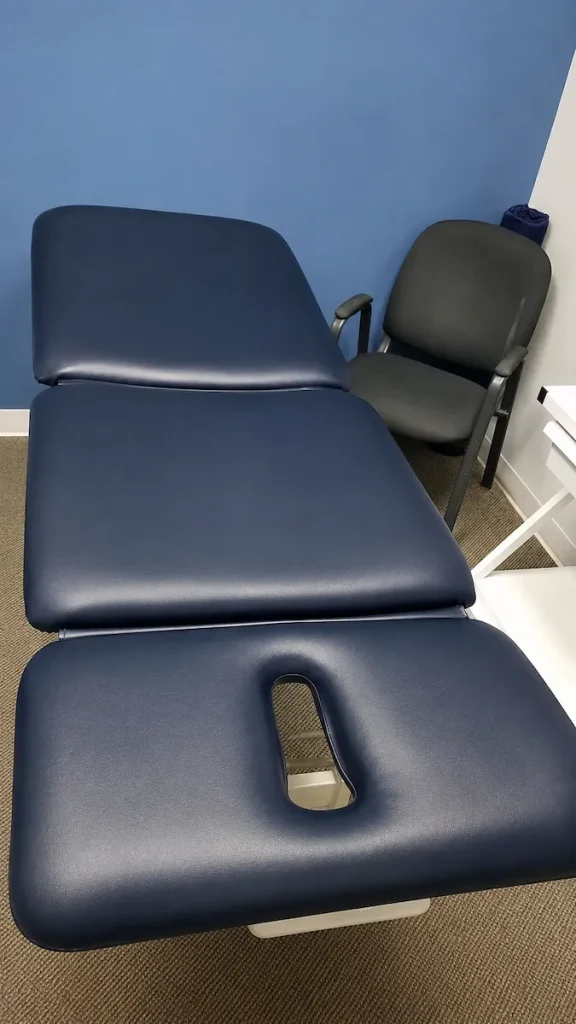 Medical exam table after dark blue vinyl reupholstery in Matthews NC